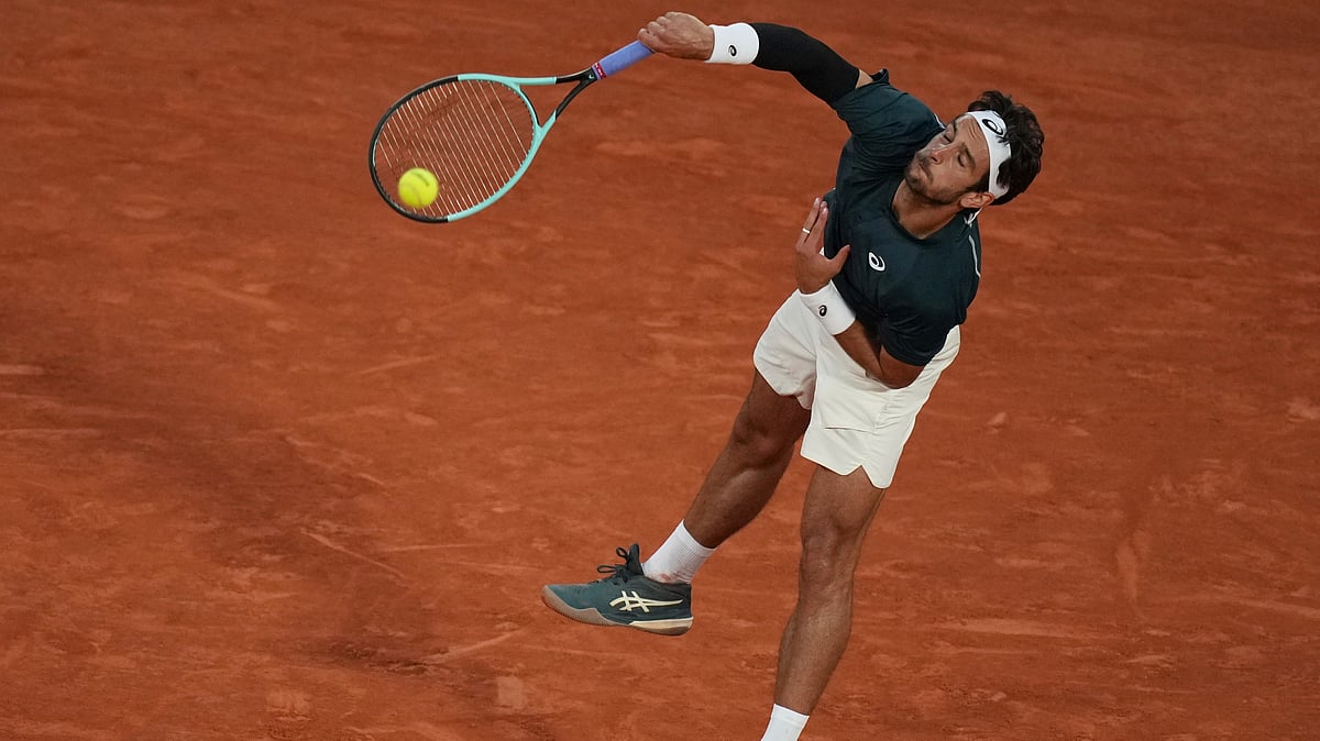 AP Photo/Christophe Ena : Italy's Lorenzo Musetti serves against Denmark's Holger Rune during their fourth round match of the French Tennis Open, at the Roland-Garros stadium, in Paris.
