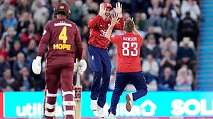 Photo: Andrew Matthews/PA via AP : England's Liam Dawson, right, celebrates after taking the wicket of West Indies' Evin Lewis during the third men's T20I at the Utilita Bowl in Southampton, England.