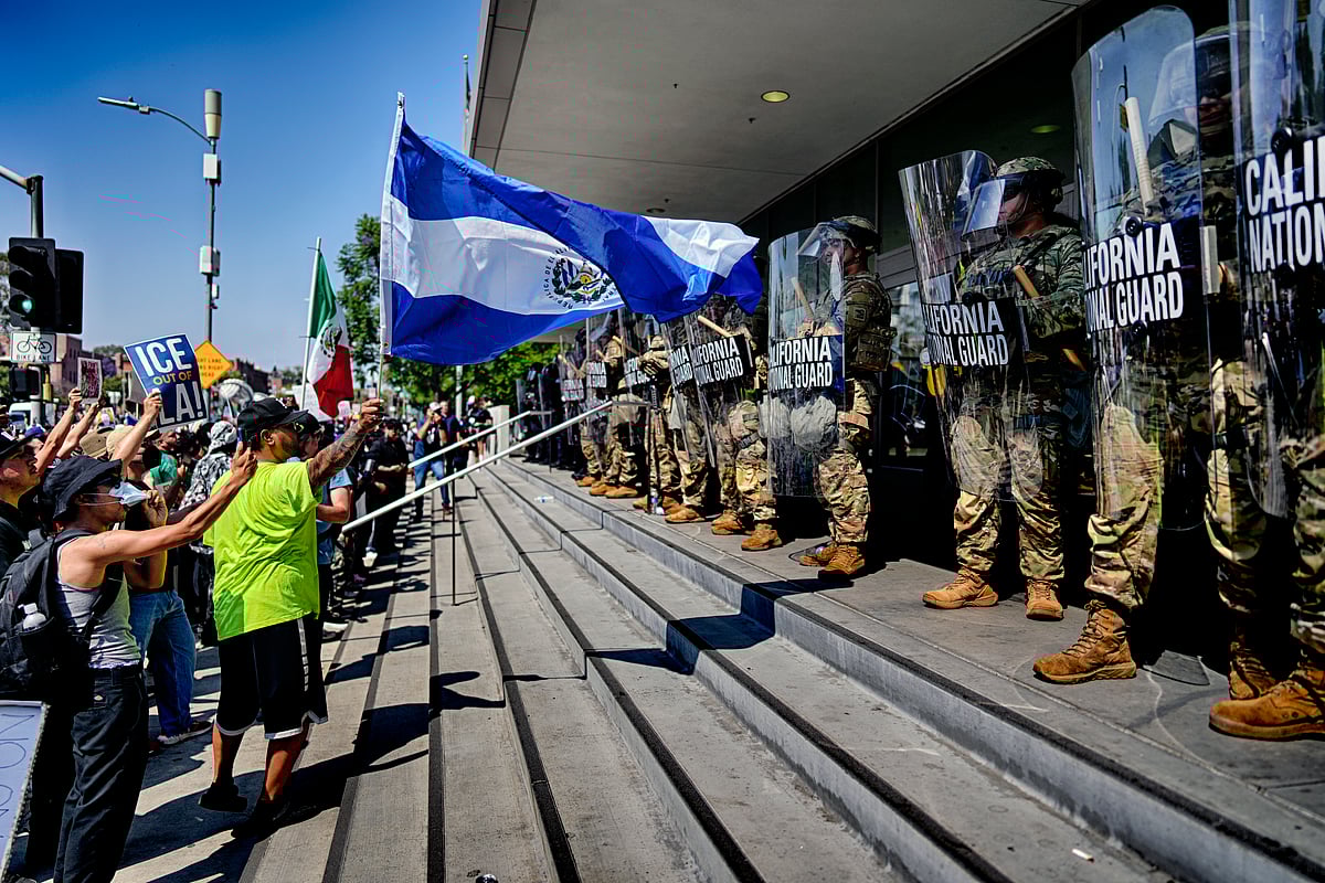 A protester waves a National Flag of El Salvador in front of a line of California National Guard in front of Federal Building on Monday, June 9, 2025, in downtown Los Angeles.  - AP Photo/Eric Thayer