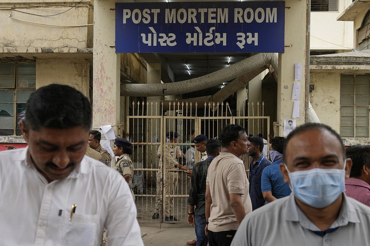 AP Photo/Rafiq Maqbool : People wait outside the autopsy room of a hospital near the Air India plane crash site in Ahmedabad