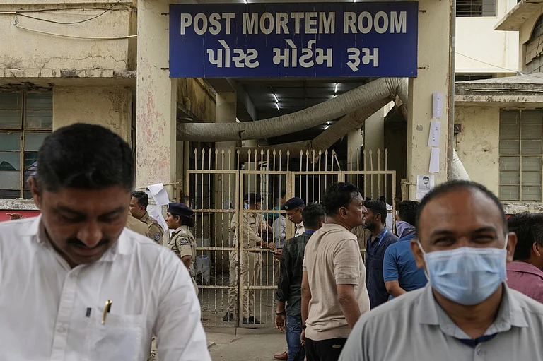People wait outside the autopsy room of a hospital near the Air India plane crash site in Ahmedabad - AP Photo/Rafiq Maqbool