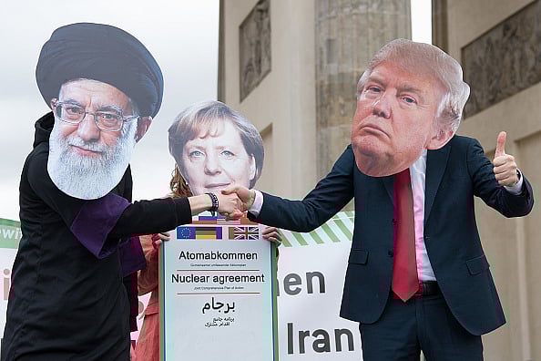 11 January 2020, Berlin: Actors dressed as religious leaders Ali Chamenei (l-r), Angela Merkel and Donald Trump perform a street theatre action as part of an anti-war demonstration. About 200 people demonstrate against a war between Iran and the USA.  -  Jörg Carstensen/dpa (Photo by Jörg Carstensen/picture alliance via Getty Images