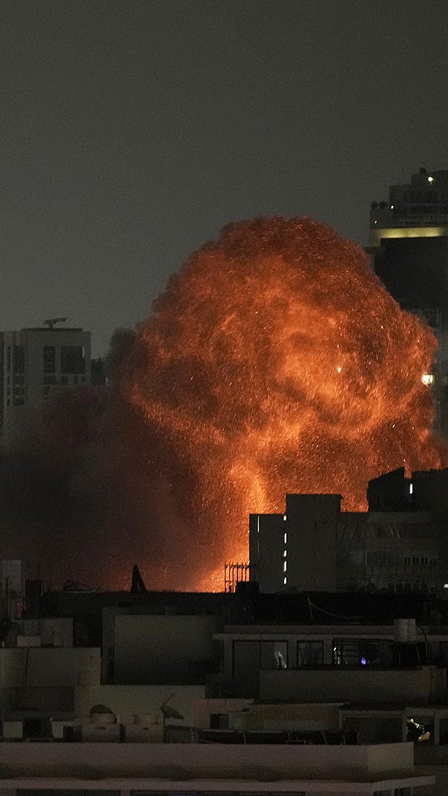 Photo: AP/Leo Correa : An explosion is seen during a missile attack in Tel Aviv, Israel