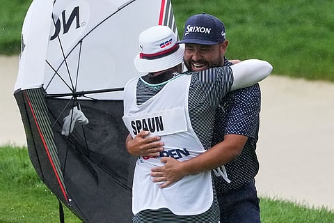 J.J. Spaun celebrates by hugging his caddie, Mark Carens