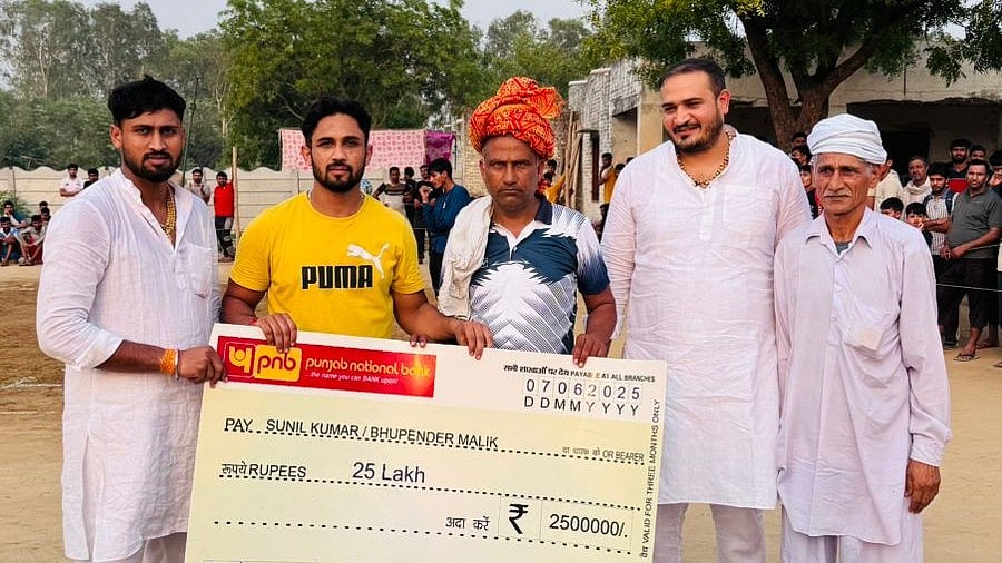 Special arrangement : Sunil Kumar presents cheque to his childhood kabaddi coach