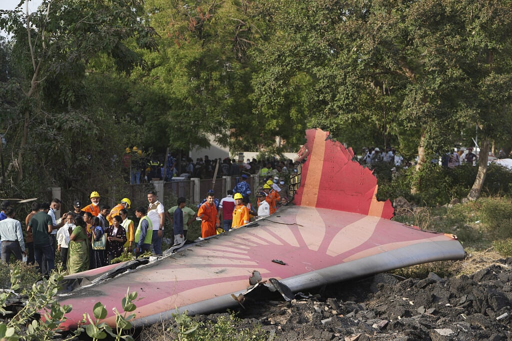 AP Photo/Ajit Solanki : People stand around the debris of an airplane after it crashed in India's northwestern city of Ahmedabad in Gujarat state, Thursday, June 12, 2025.