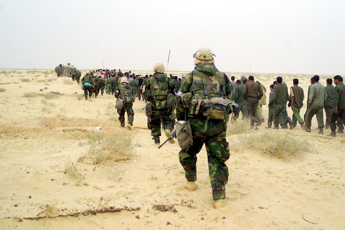 LCPL BL WICKLIFFE : US Marines escort captured enemy prisoners to a holding area in the desert of Iraq 