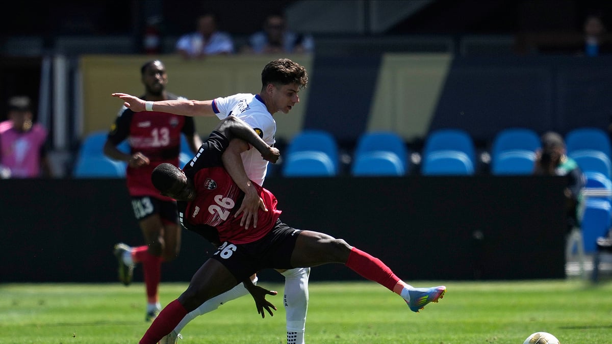 AP Photo/Jeff Chiu : Trinidad and Tobago forward Isaiah Lee (26) reaches for the ball against United States midfielder Max Arfsten, top right, during the first half of a CONCACAF Gold Cup football match in San Jose.