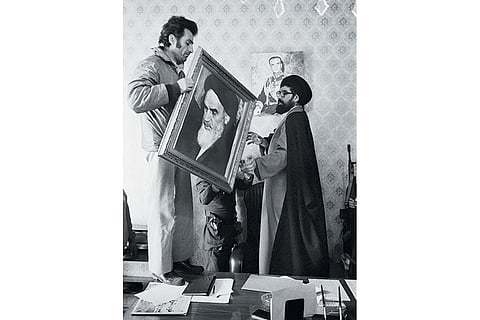 Palace employees replace a portrait of Shah Reza Pahlavi with one of Ayatollah Khomeini at the Niavaran Palace in Tehran