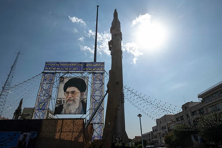 An Iranian Sejjil ballistic missile pictured next to the portrait of Ayatollah Ali Khamenei in Tehran - Photo by Morteza Nikoubazl/NurPhoto via Getty Images