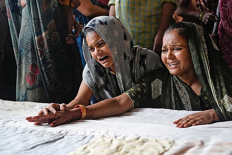 Family members of fifteen-year-old Akash Patni at his funeral. His mother, who owned a tea stall next to the crash site, has suffered severe burns and has been admitted to the hospital
