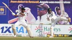 AP Photo/Eranga Jayawardena : Sri Lanka's Kamindu Mendis plays a shot as Bangladesh's Litton Das watches during day three of the first cricket test match between Sri Lanka and Bangladesh in Galle, Sri Lanka.