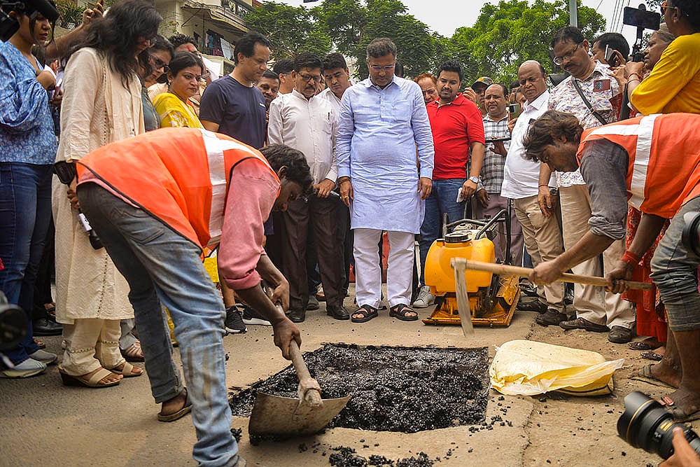 | Photo: PTI : PWD workers repair a road