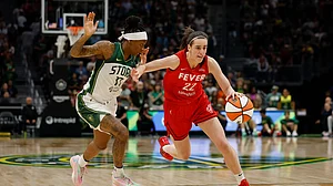 Caitlin Clark #22 of the Indiana Fever dribbles past Erica Wheeler #17 of the Seattle Storm during the third quarter at Climate Pledge Arena on June 24, 2025 in Seattle, Washington. The Indiana Fever won 94-86.
