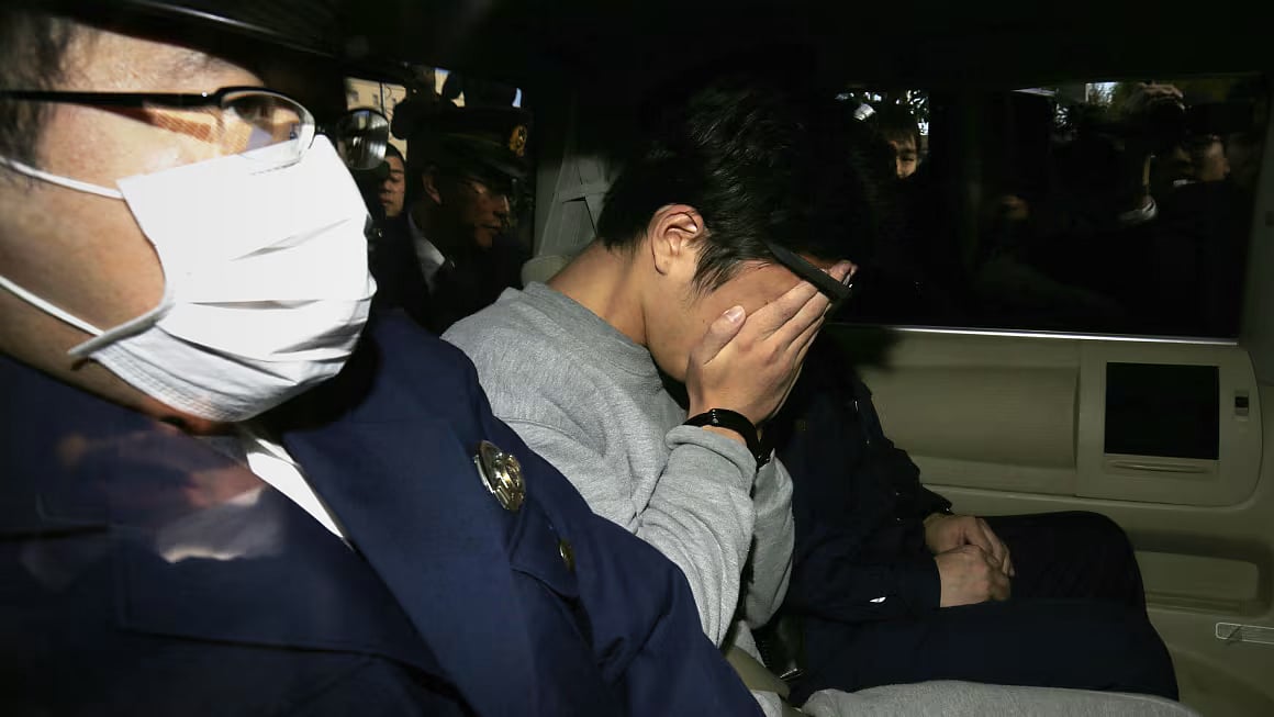 STR/AFP/Getty Images : Takahiro Shiraishi covers his face with his hands as he is transported to the prosecutor's office from a police station in Tokyo on November 1, 2017. 