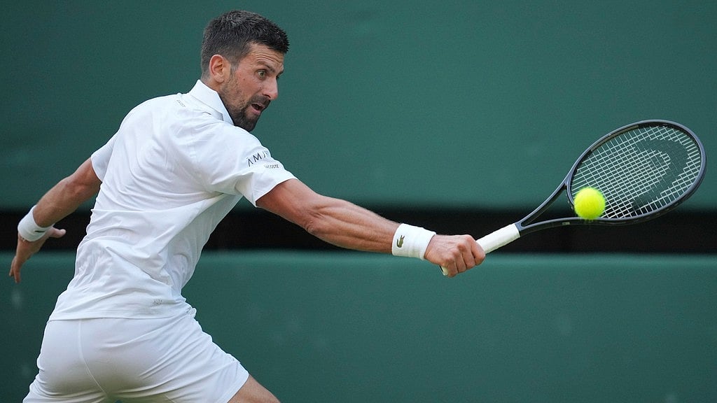 Photo: AP : Novak Djokovic of Serbia returns to Alexandre Muller of France during their first-round men's singles match at the Wimbledon Tennis Championships in London.