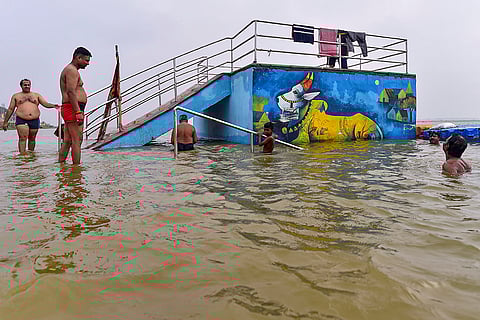 People take a holy dip amid rising Ganga water level in Prayagraj