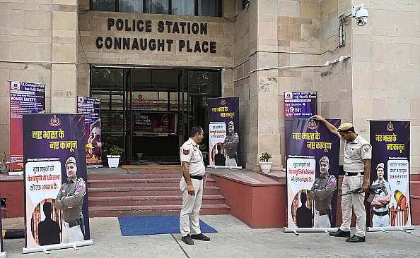 Photo by Sonu Mehta/Hindustan Times via Getty Images : Police install posters about the new criminal laws put up outside Parliament Street Police Station in New Delhi