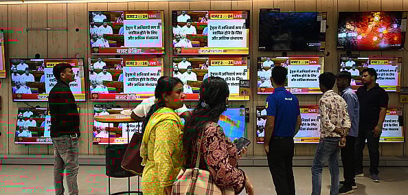 Photo by Sonu Mehta/Hindustan Times via Getty Images : People watch Union Budget 2024-25 being presented by Finance Minister Nirmala Sitharaman in the Parliament on the television screen at the TV showroom at Vijay sales Darya Ganj on July 23, 2024 in New Delhi, India.