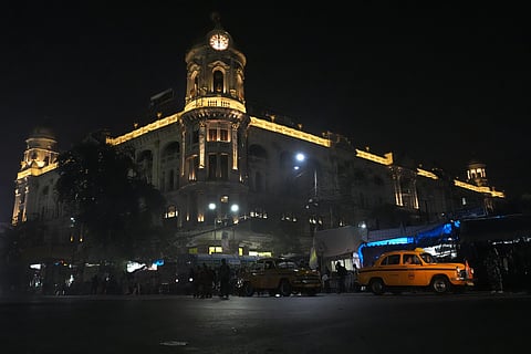 Yellow taxi at Chowringhee on the backdrop of Kolkata's heritage building Cottage Emporium/ OldLIC building. 