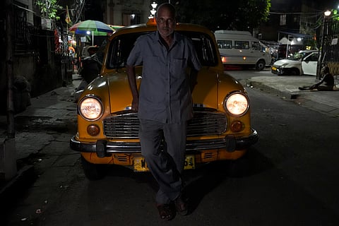B. Kamath, a 52-year-old man from Madhubani district in Bihar, is considering driving a private car if taxis are discontinued. He lives with his wife and three sons. His eldest son works at a saree shop in Bangalore, while the other two sons are at home studying. He has been driving his current taxi is valid for more 2 years and 6 months. Kamath has been driving yellow taxis since 1987 and has a deep attachment to them.
