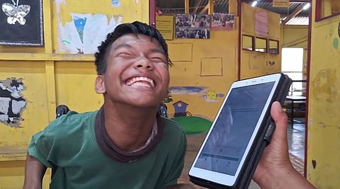 A student at the Centre for Community Initiative in Lamka, beams as he uses the My First Voice app. This AI tool allows non-verbal children to communicate in voices that echo their own.