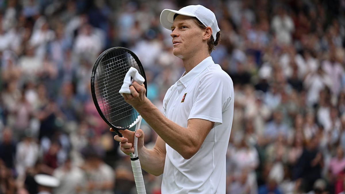 Jannik Sinner punches the air after converting match point.