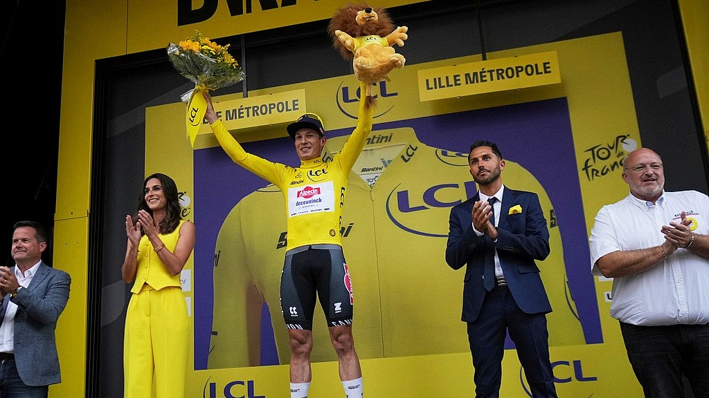 AP : Belgium's Jasper Philipsen wearing the overall leader's yellow jersey celebrates on the podium after winning the first stage of the Tour de France cycling race over 184.9 kilometers (114.9 miles) with start and finish in Lille, France.