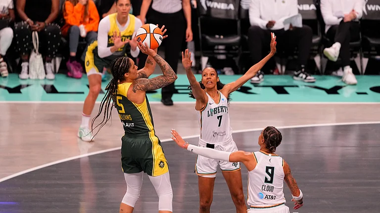 Seattle Storm Forward Gabby Williams (5) shoots a jump shot over New York Liberty Guard Rebekah Gardner (7) and New York Liberty Guard Natasha Cloud (9) during the second half of the WNBA game between the Seattle Storm and the New York Liberty on July 6, 2025, at the Barclays Center in Brooklyn NY. - null