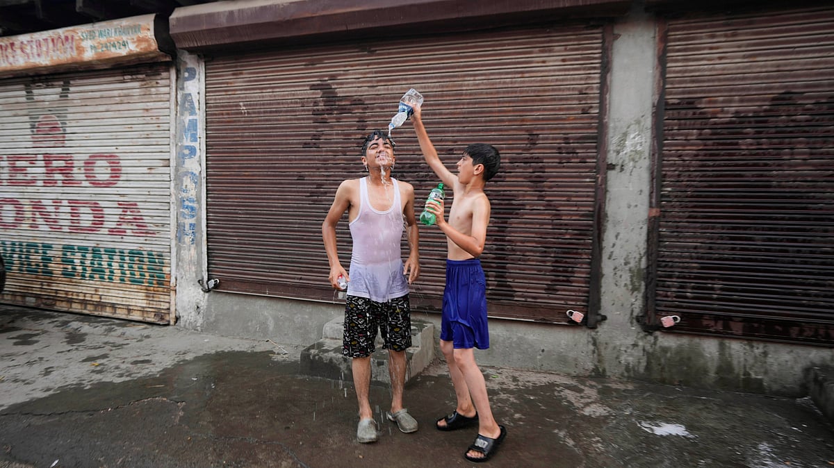 Mukhtar Khan - AP     : A boy pours water on his friend as they cool off on a hot summer day in Srinagar, Kashmir, Tuesday, June 24, 2025.