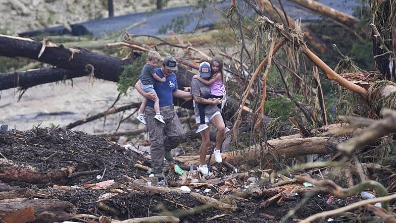 | AP | : People climb over debris on a bridge atop the Guadalupe River after a flash flood swept through the area Saturday, July 5, 2025, in Ingram, Texas. (AP Photo/Julio Cortez)
