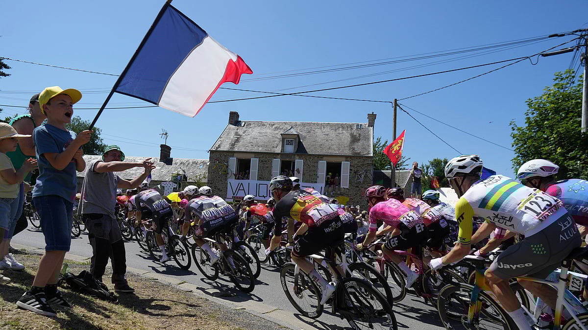 AP Photo/Thibault Camus : A boy waves a French flag as the pack rides during the sixth stage of the Tour de France cycling race over 201.5 kilometres (125.2 miles) with start in Bayeux and finish in Vire, Normandy, France.