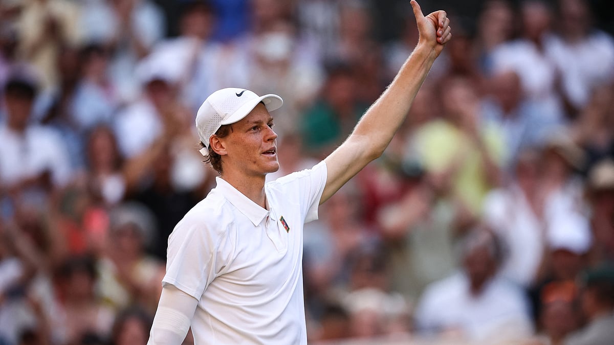 Jannik Sinner offers fans a thumbs-up after beating Novak Djokovic