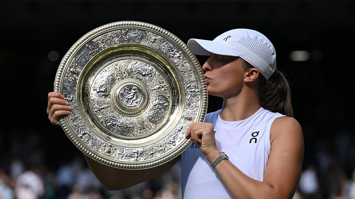 Iga Swiatek kisses the Wimbledon trophy