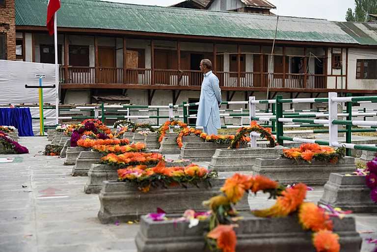 A Kashmiri man pays tribute next to graves of 22 civilians at Martyr's graveyard in Srinagar. July 13 is observed as Martyrs Day in Jammu and Kashmir to remember those 22 civilians killed in the firing outside the Srinagar Central Jail by forces of the Dogra Maharaja in 1931 | - gettyimages |