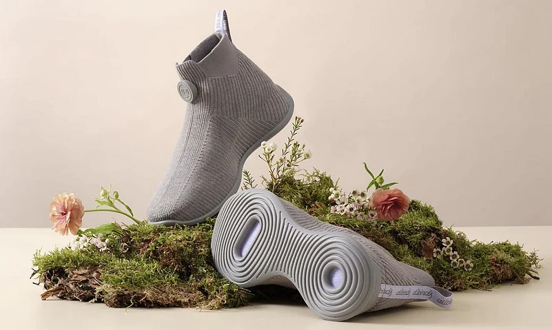 Eco-friendly sneakers placed on moss with flowers