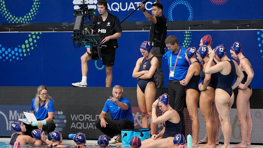 AP : United States head coach Adam Krinkorian, speaks with the players during the women's water polo preliminary round against Argentina at the World Aquatics Championships in Singapore.