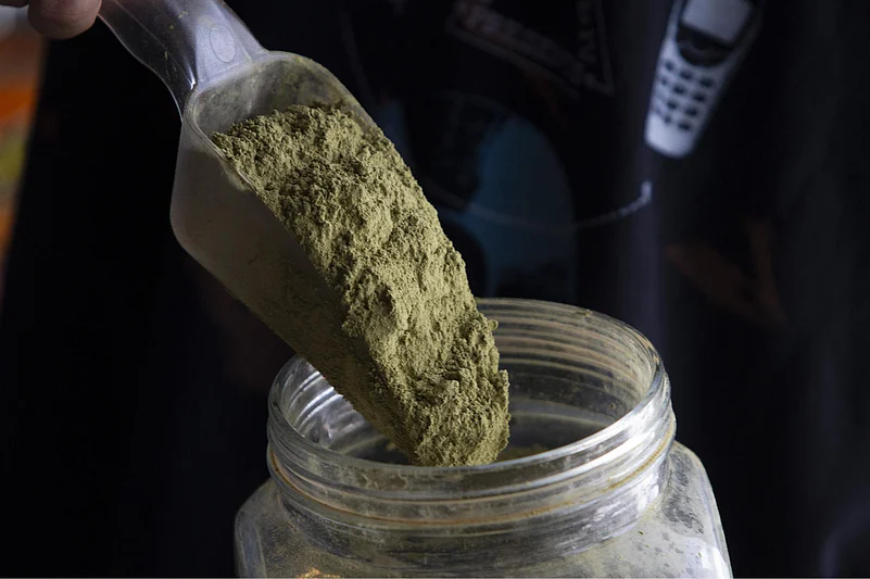 Spoon scooping green powder from a jar