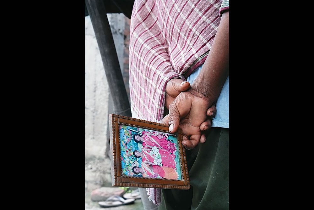 | Photo: Tribhuvan Tiwari : In Mourning: A relative carries a photo of one of his family members who was branded a witch and killed at Tetgama on July 6, 2025 