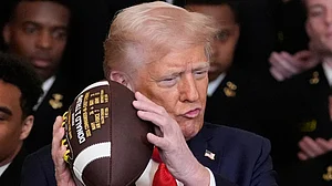 AP/Alex Brandon : Donald Trump holds a football during the Commander-in-Chief Trophy presentation to the Navy Midshipmen football team in the East Room of the White House in Washington on April 15, 2025.