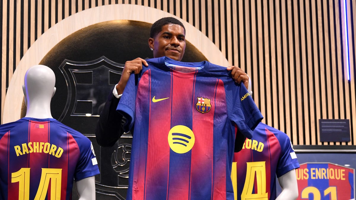 Marcus Rashford holds up his Barca shirt.