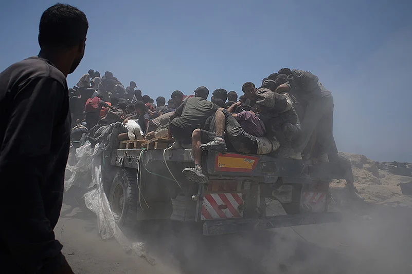 Palestinians hold onto an aid truck