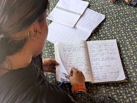 Poonam's youngest daughter who's now married, shows her tuition copy.