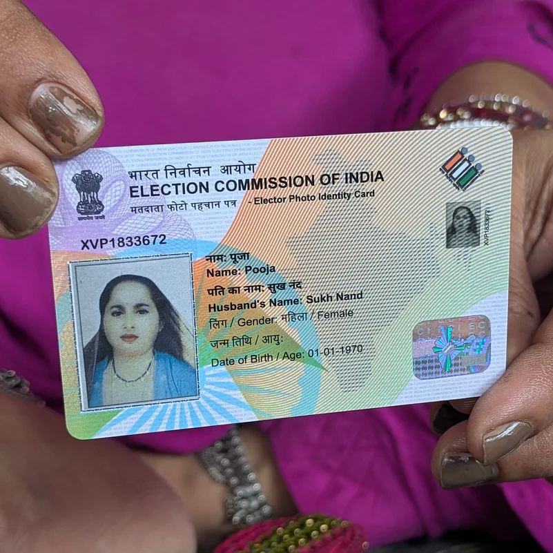 Pooja shows her voter card.