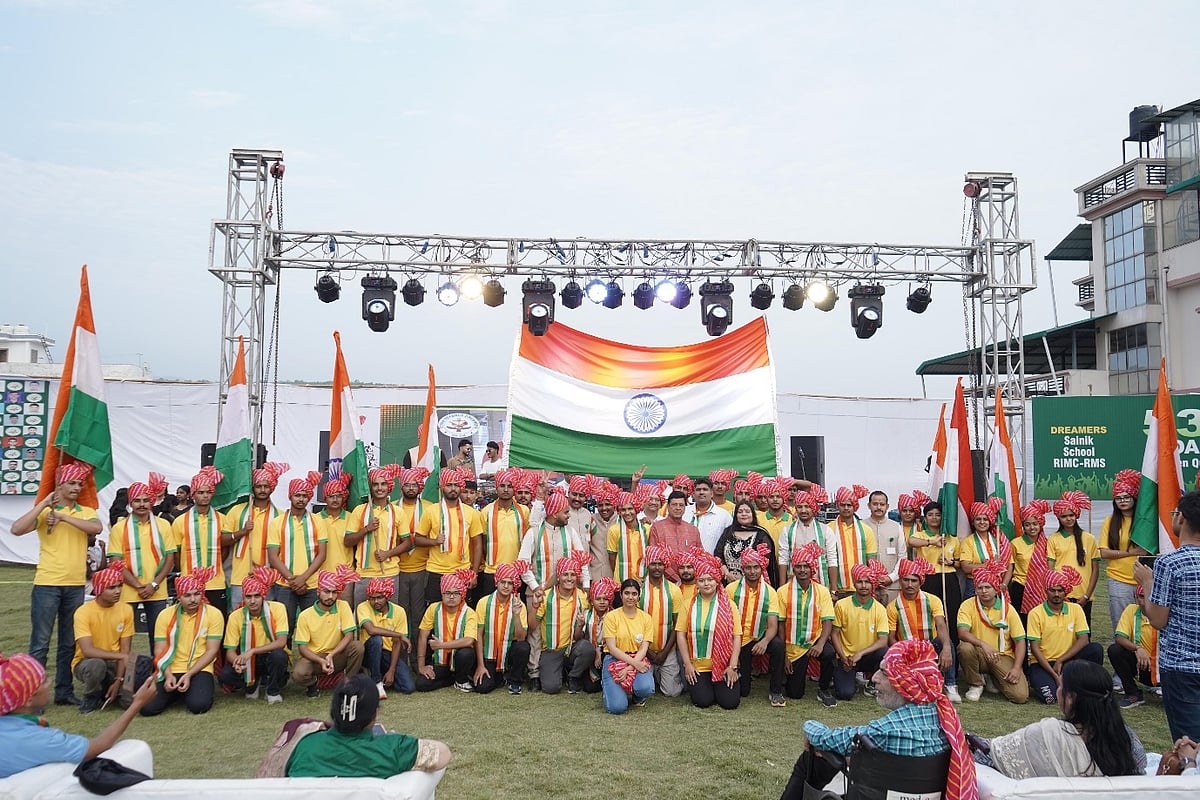 Students with flags on stage under indian tricolor at Doon Defence Dreamers event