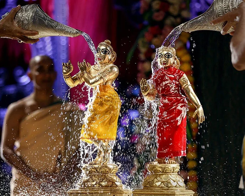 Lord Krishna and Radha ji are being given a bath
