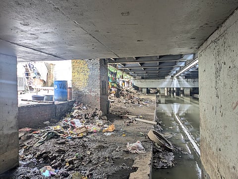 Garbage and stagnant water under the flyover mark hazardous living conditions. 