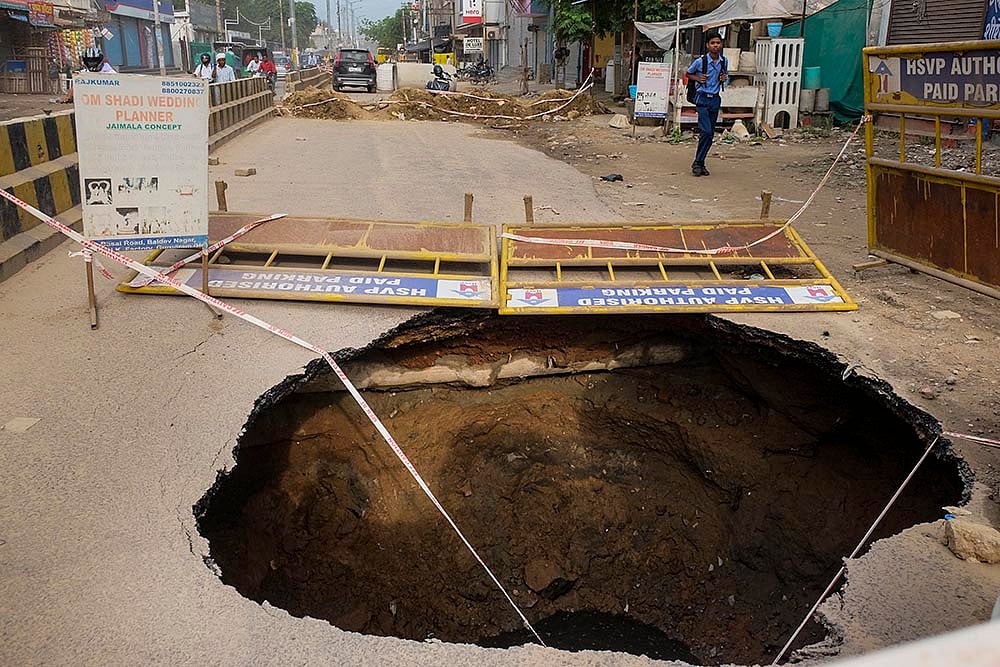| Photo: PTI : Gurugram Road caved in