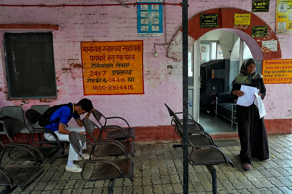 A woman standing beside a mental health centre advertisement  - SURESH K PANDEY