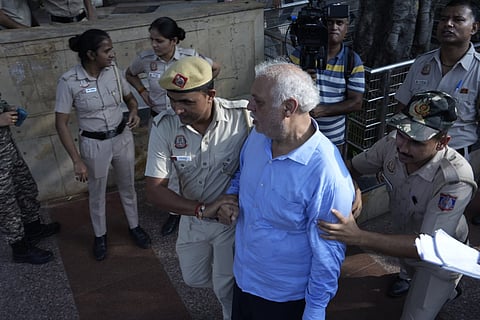An elderly man being taken to the bus after being detained |